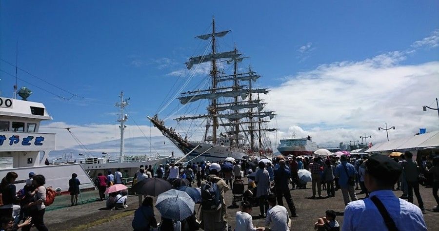 A group of people are standing in front of a large ship.