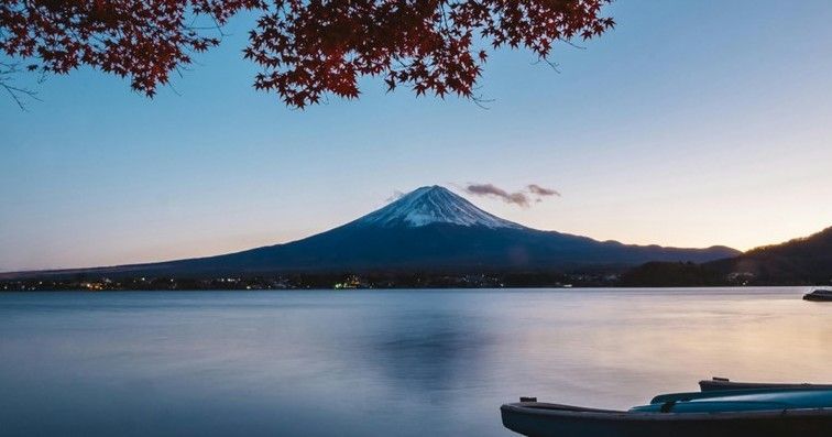 A lake with Mt. Fuji in the background and a boat in the foreground.