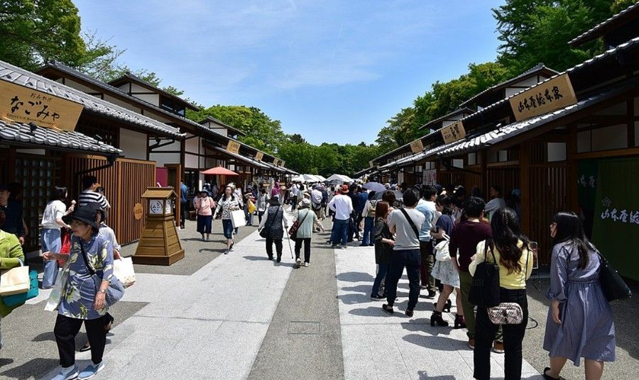 A group of people are walking down a narrow street.