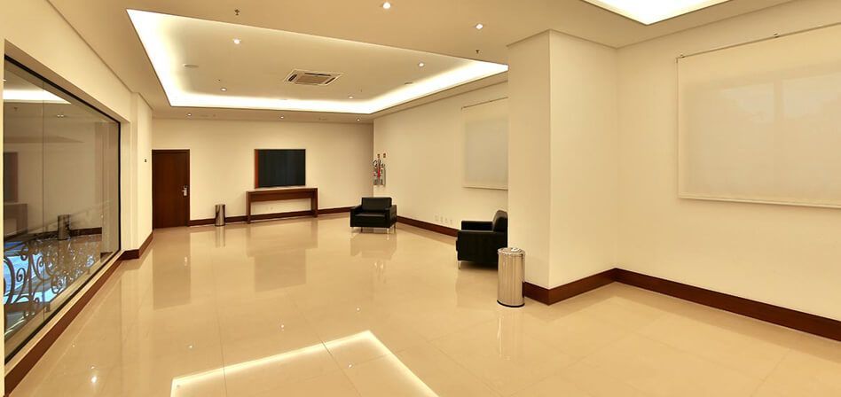 Uma grande sala vazia com piso de mármore e paredes brancas