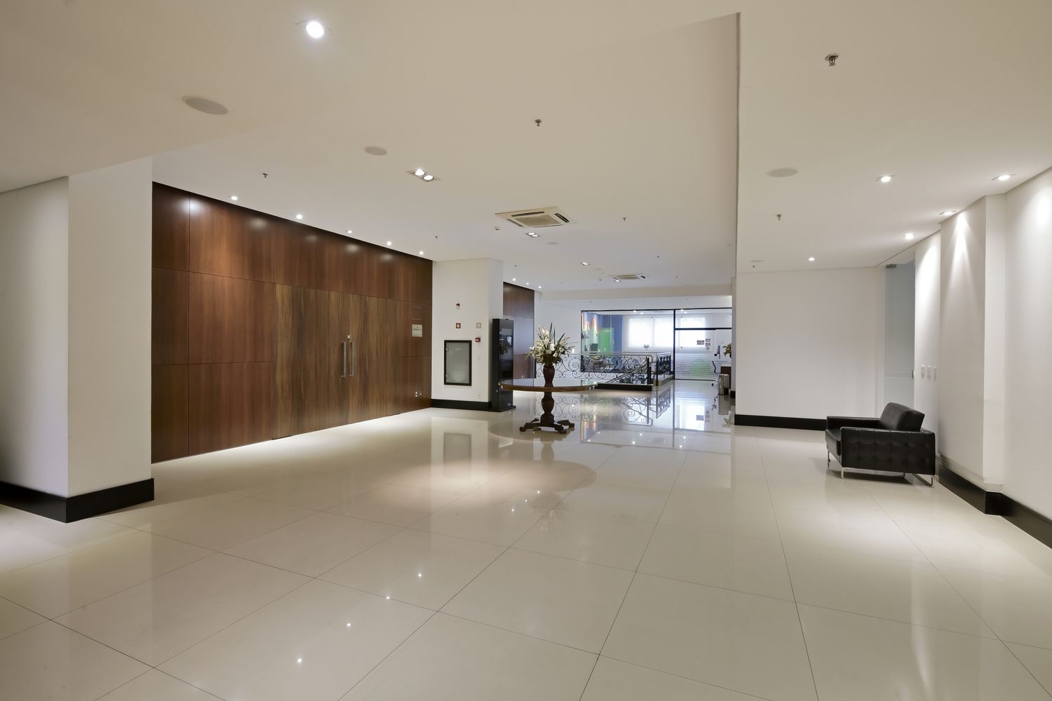 Um grande saguão vazio com uma mesa e cadeiras