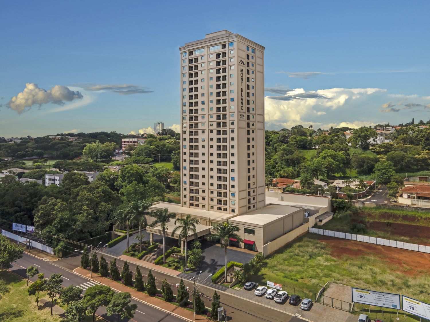 Uma vista aérea de um edifício alto em uma cidade cercada por árvores.