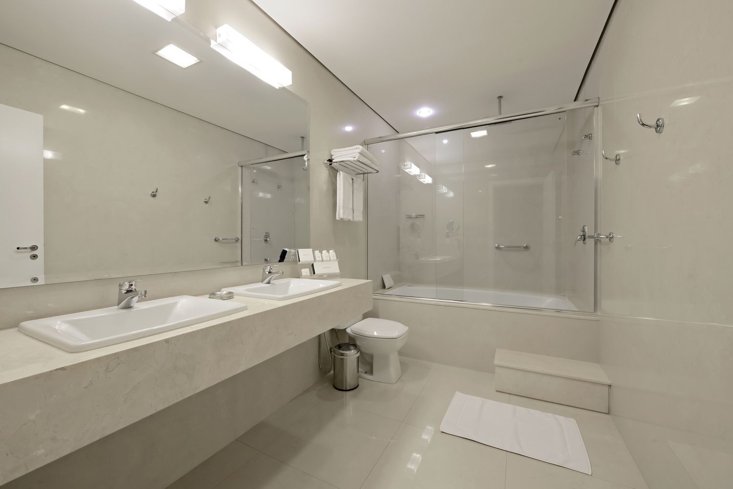 Um banheiro com vaso sanitário, pia, espelho e banheira.