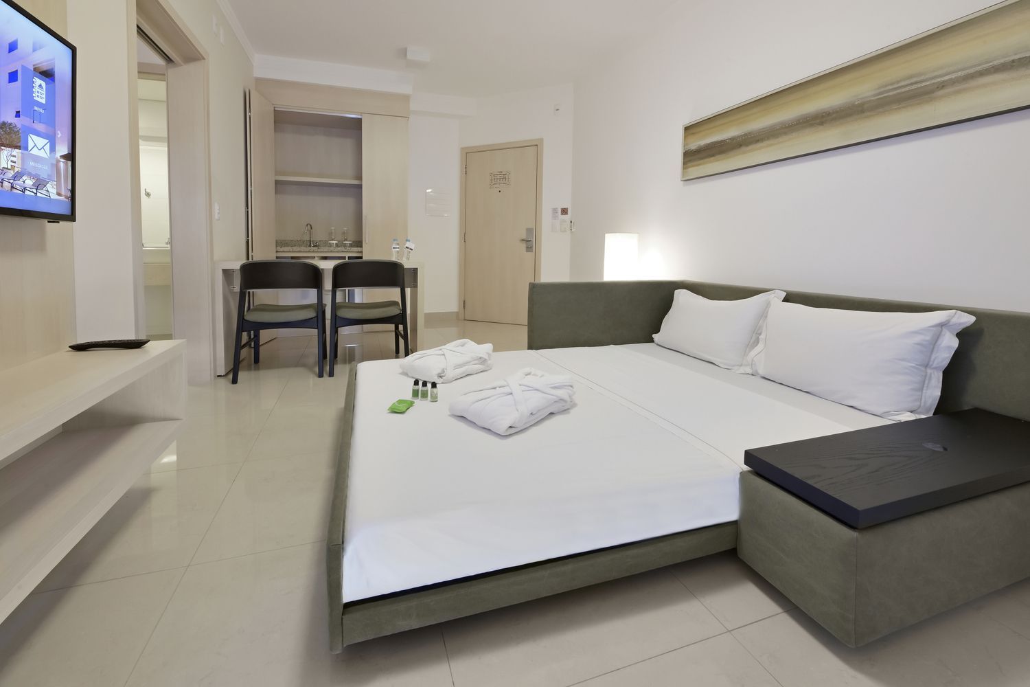 Uma grande academia com esteiras, pesos e um grande espelho.