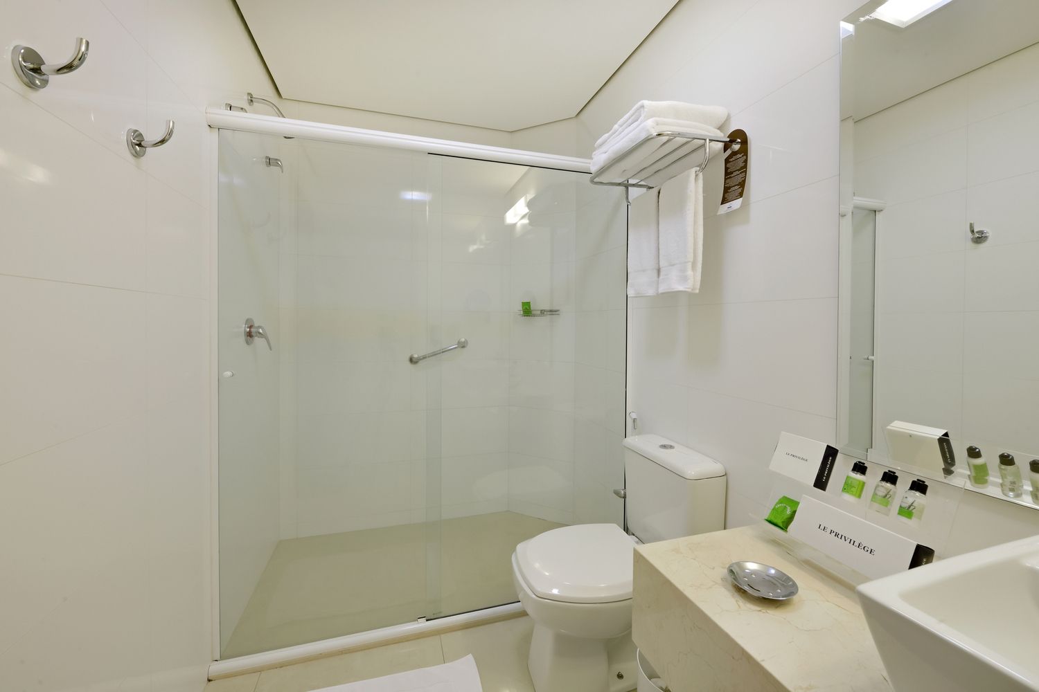 Um lobby de hotel com balcão de recepção e cadeiras.