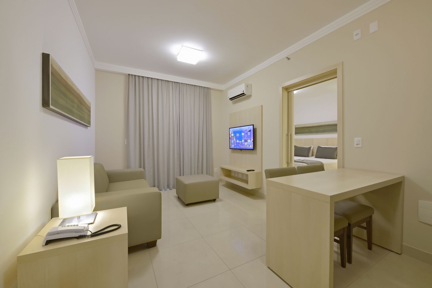 Uma sala de estar com um sofá, cadeiras e pufe.