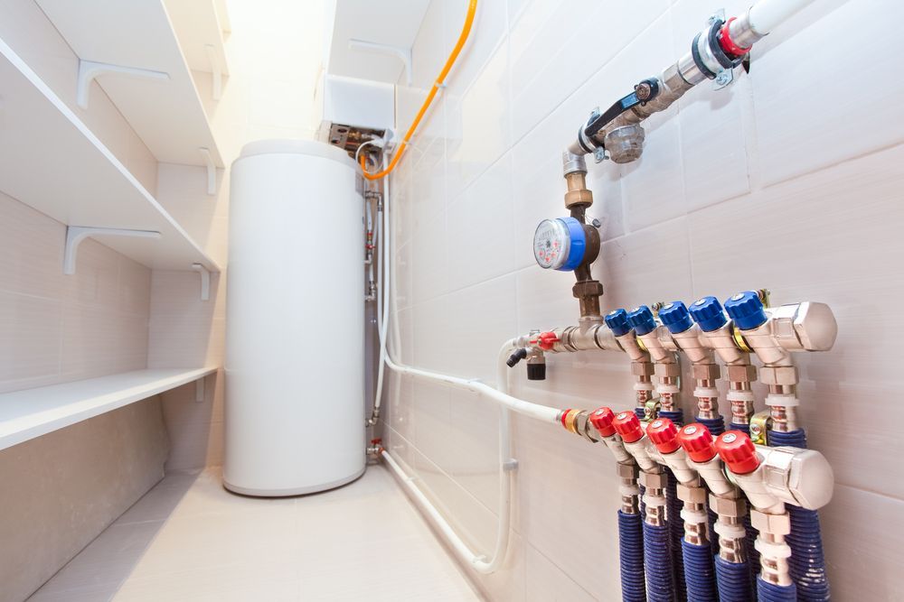 White Water Heater and Plumbing in a Utility Room With Shelves — Waves Plumbing in Gosford, NSW