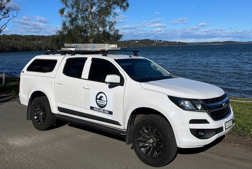 White Truck With Black Wheels Parked Near Water — Waves Plumbing in Central Coast, NSW