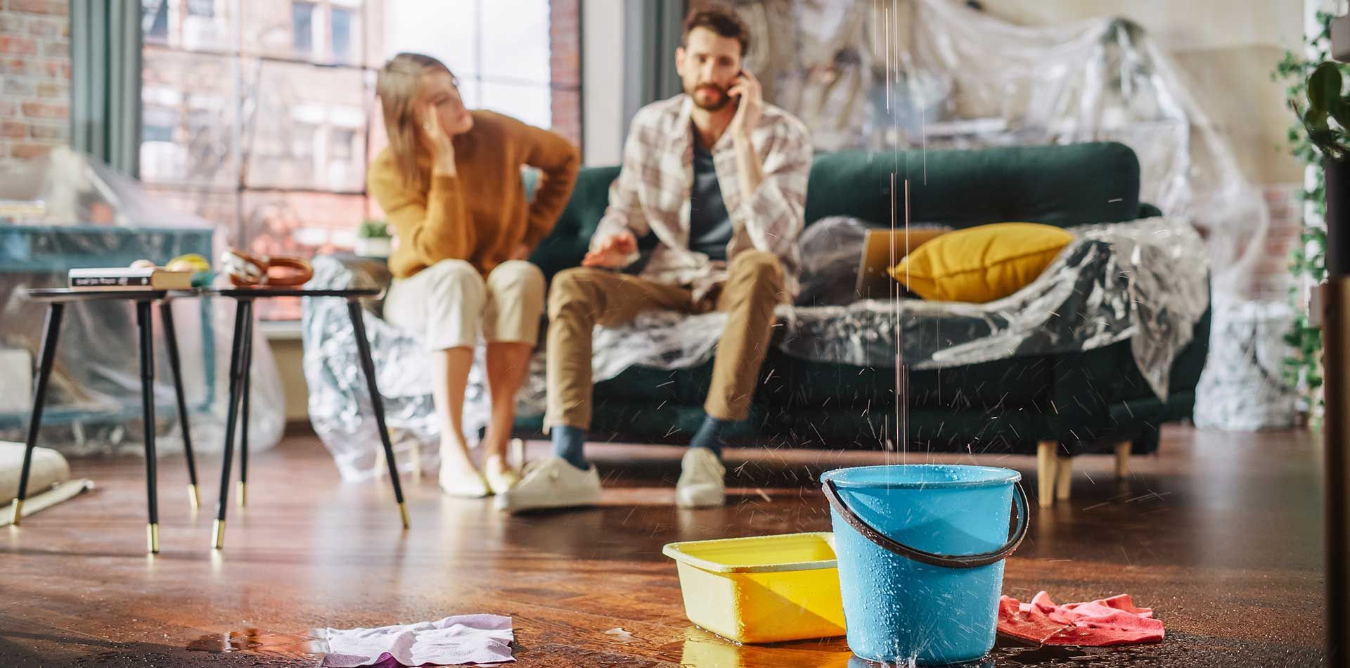 A Couple in Distress, Sitting in a Water-damaged Living Room — Waves Plumbing in Central Coast, NSW