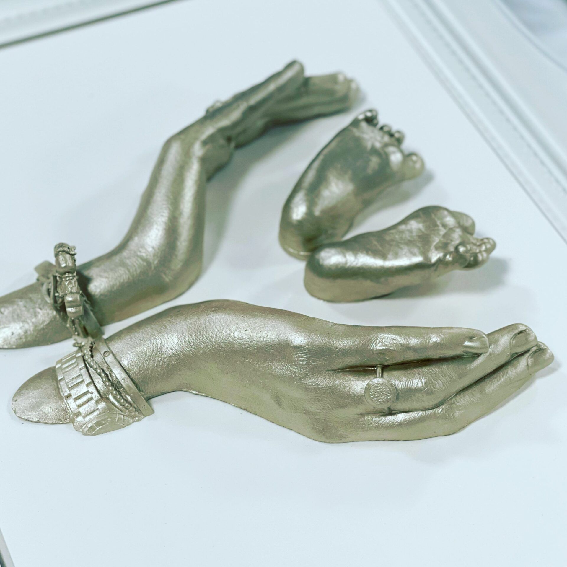 A hand with a ring on it is next to a baby 's foot