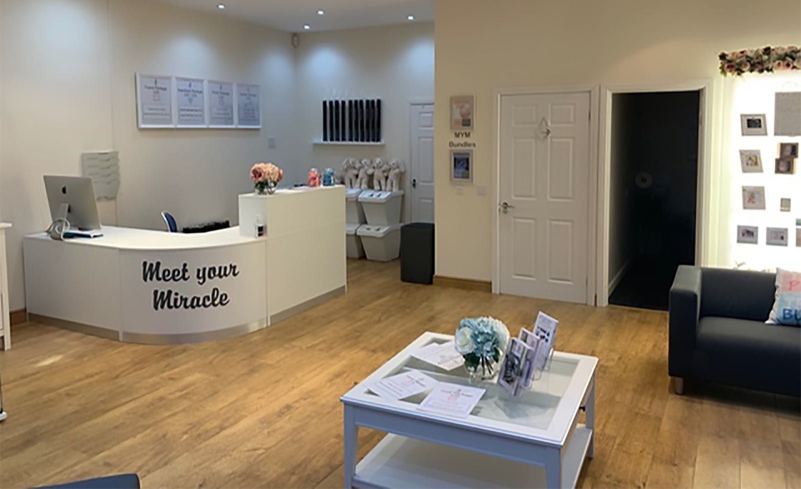 A living room with a couch and a table and a counter that says meet your miracles.