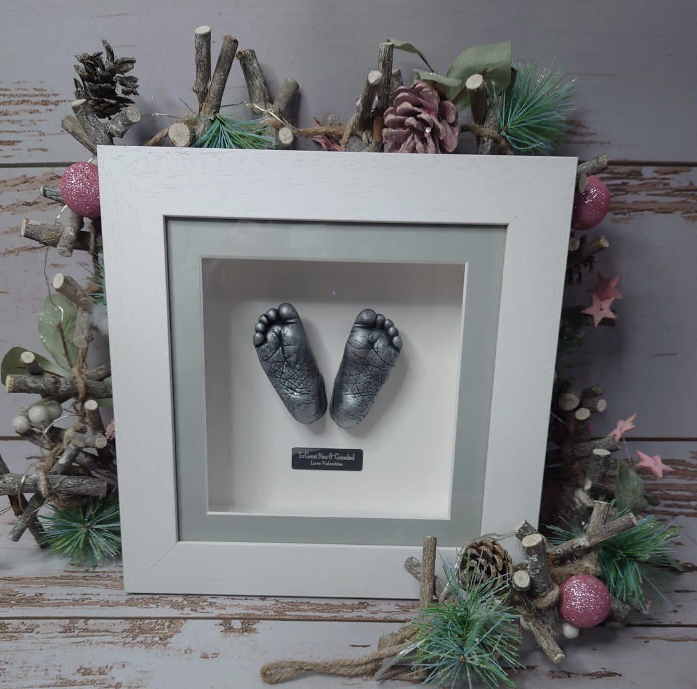 A picture of a baby 's feet in a white frame