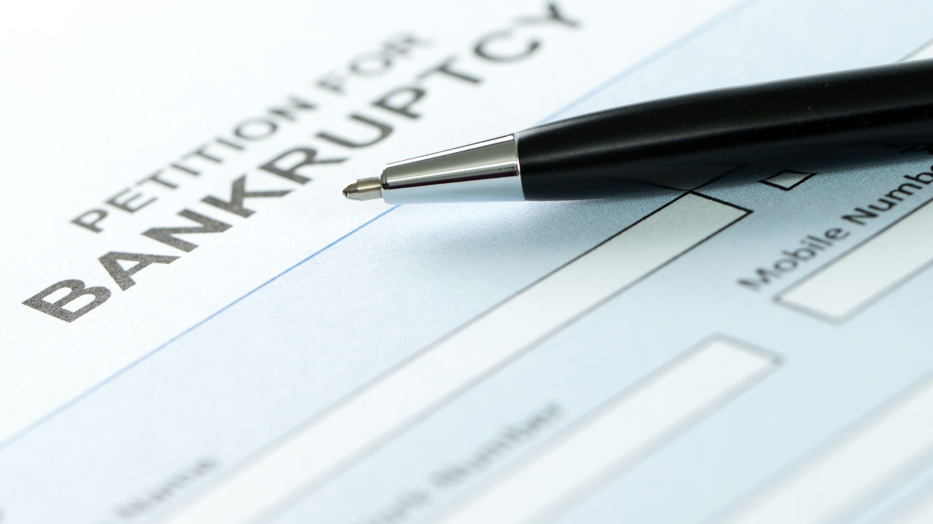 A pen rests on a bankruptcy petition.