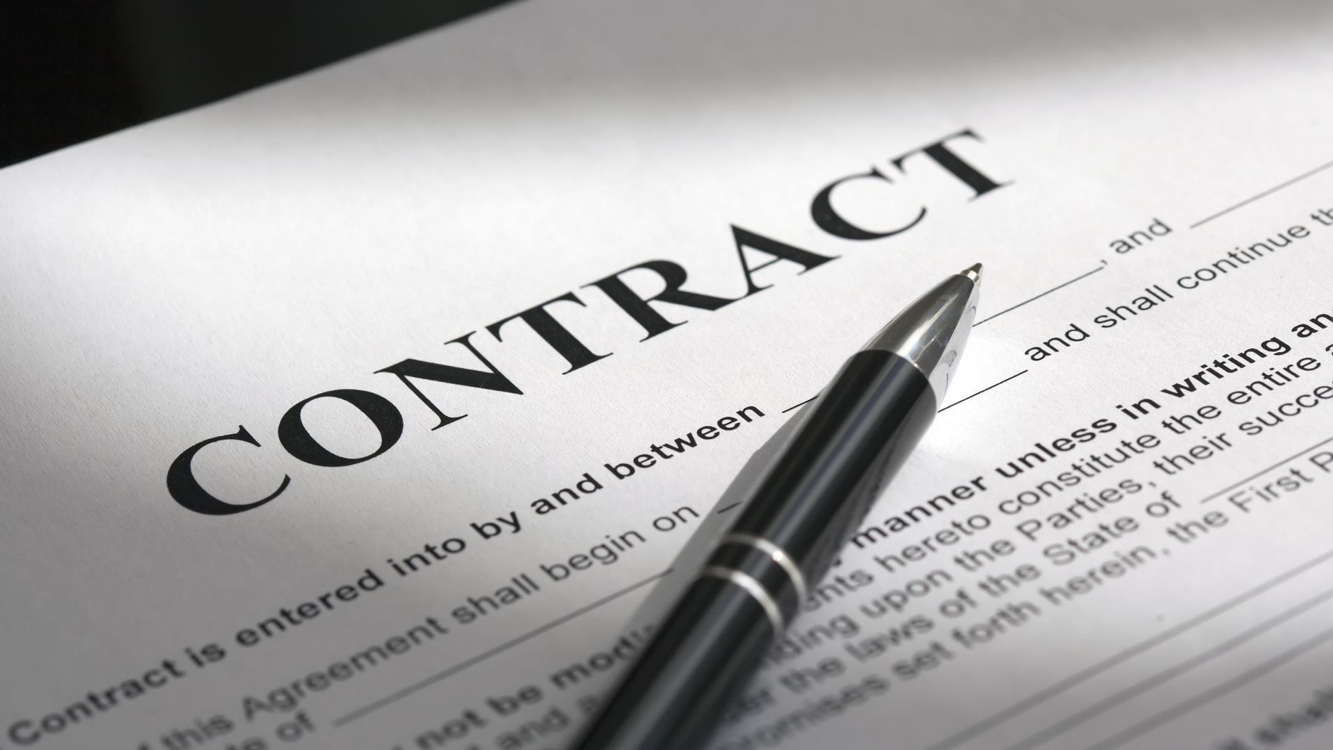 Contract document with a pen resting on it.