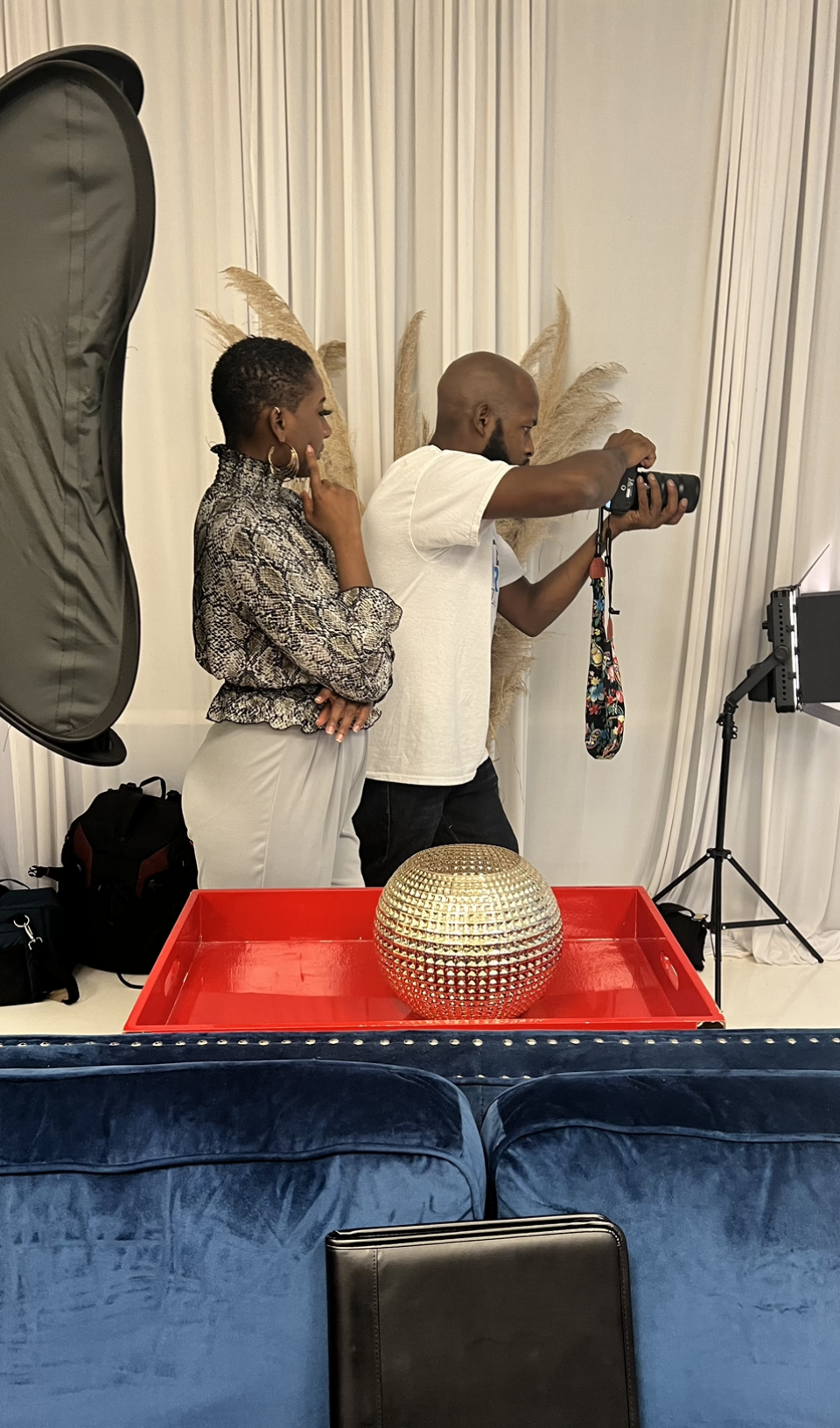 A man is taking a picture of a woman in a living room.