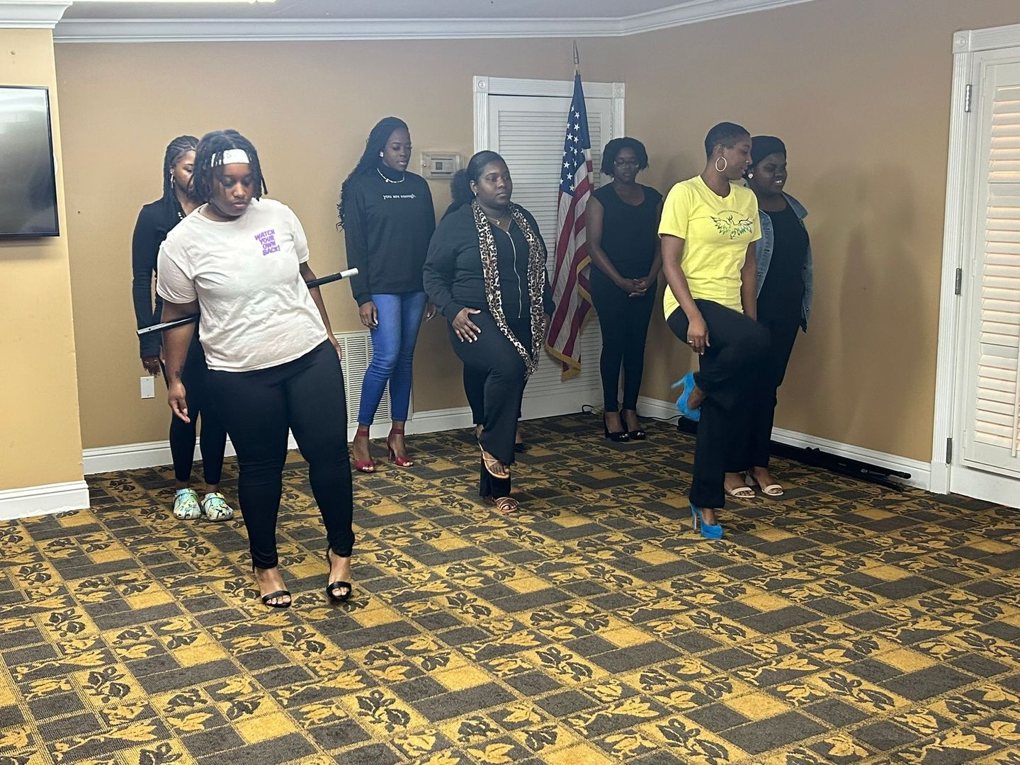 A group of women are standing in a room dancing.