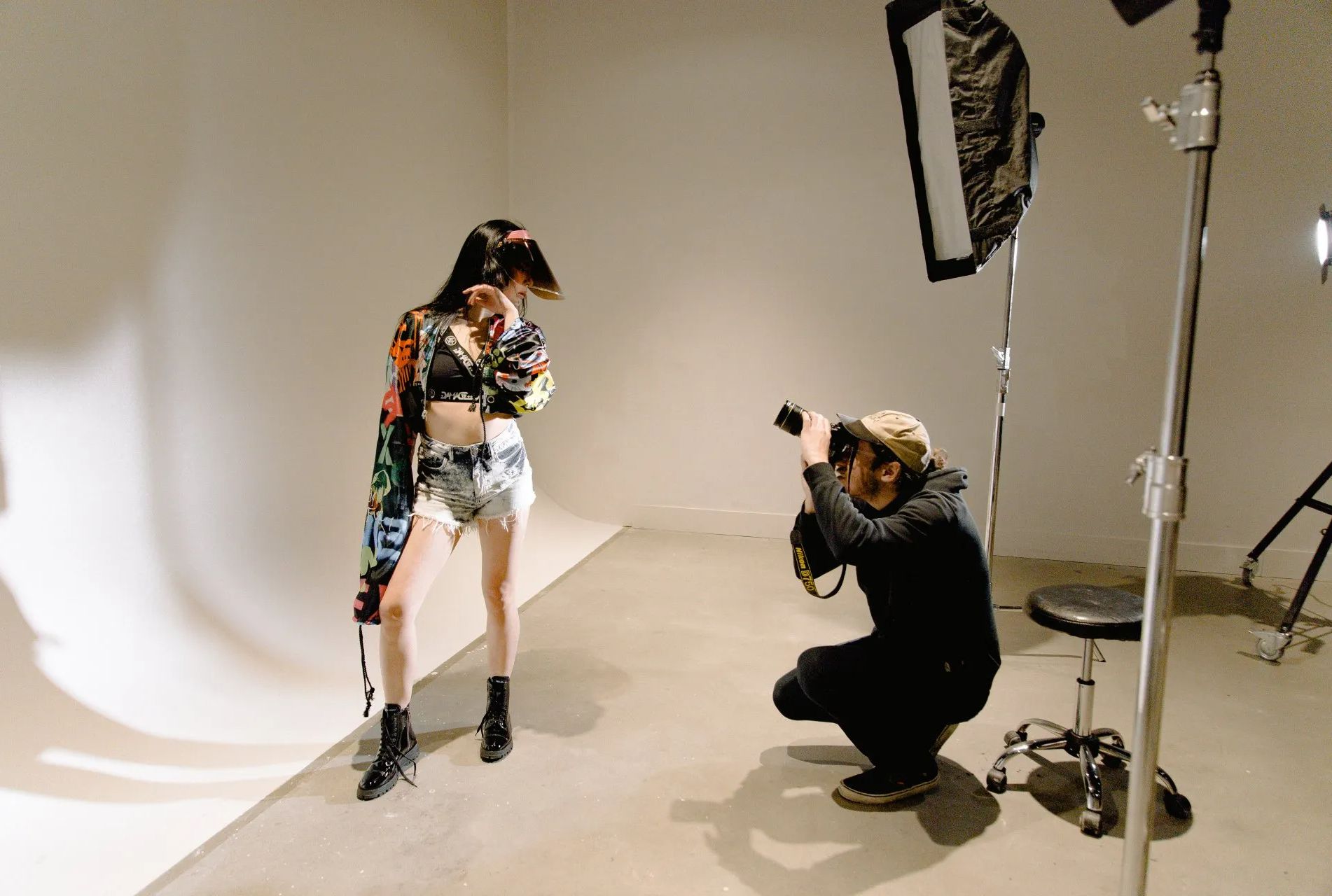A man is taking a picture of a woman in a studio.