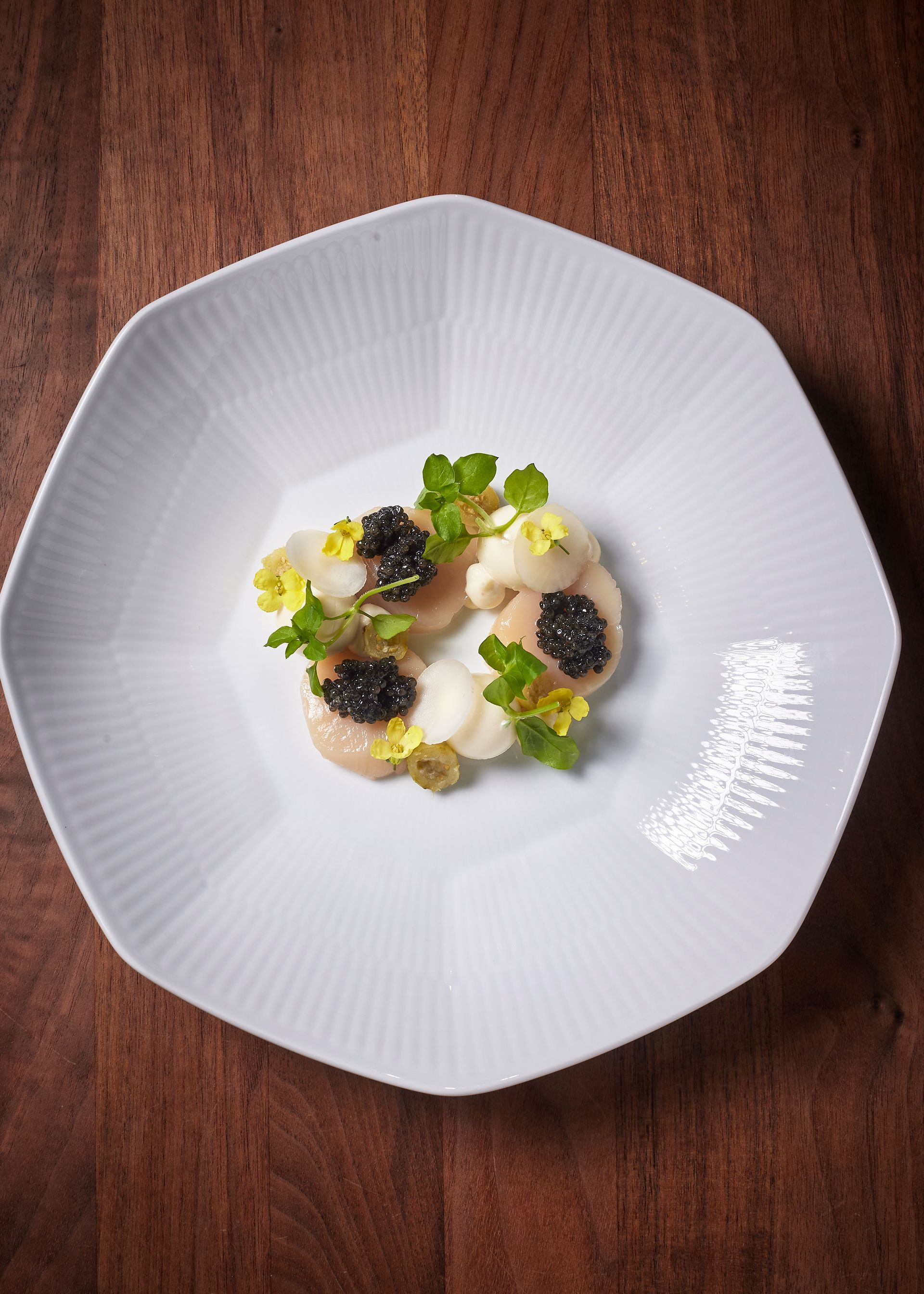 Et værelse med to senge og en lysestage på væggen.