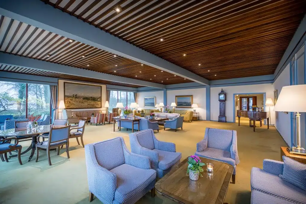 Et stort værelse med mange møbler og træloft.