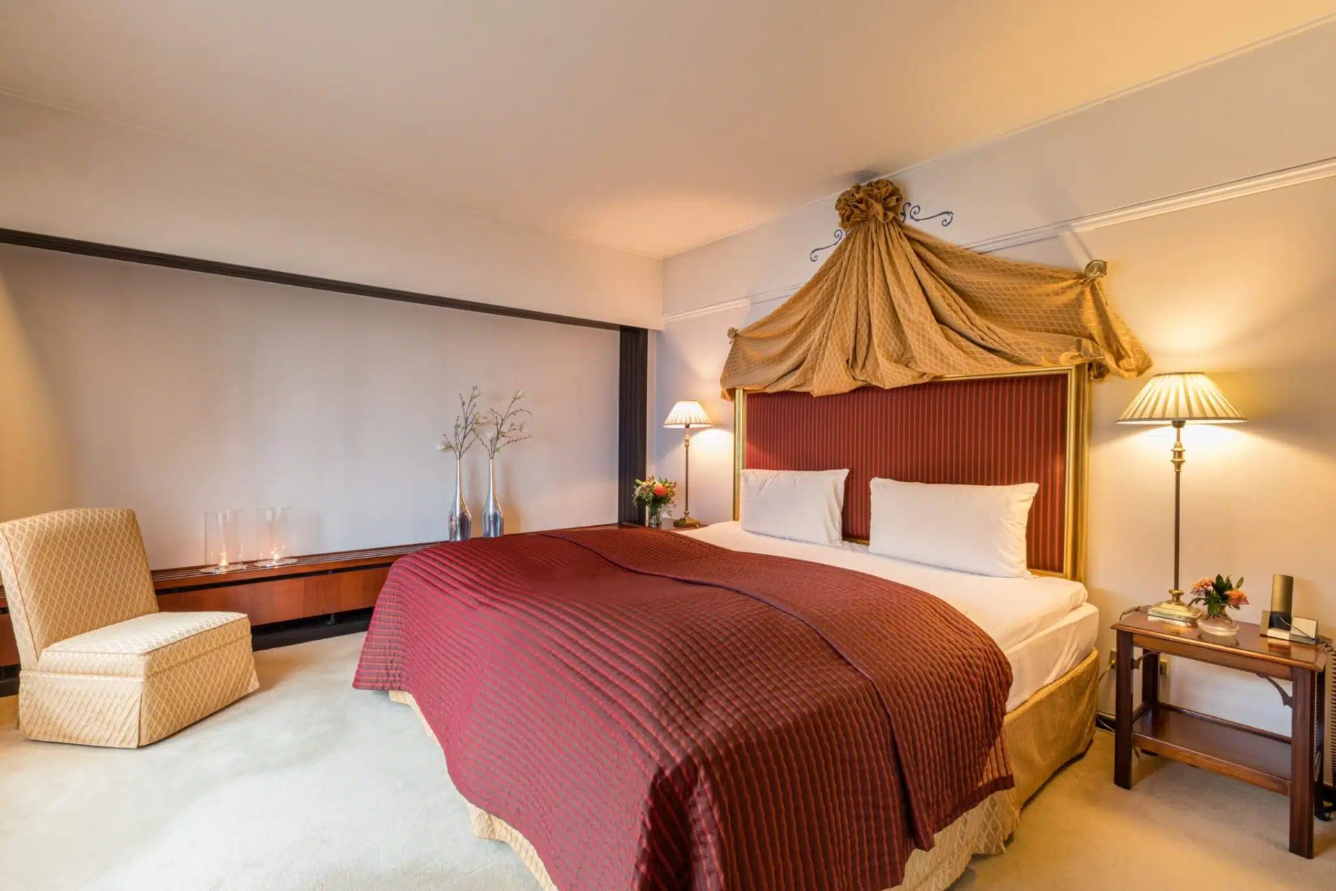 Et hotelværelse med en stor seng og en stol.