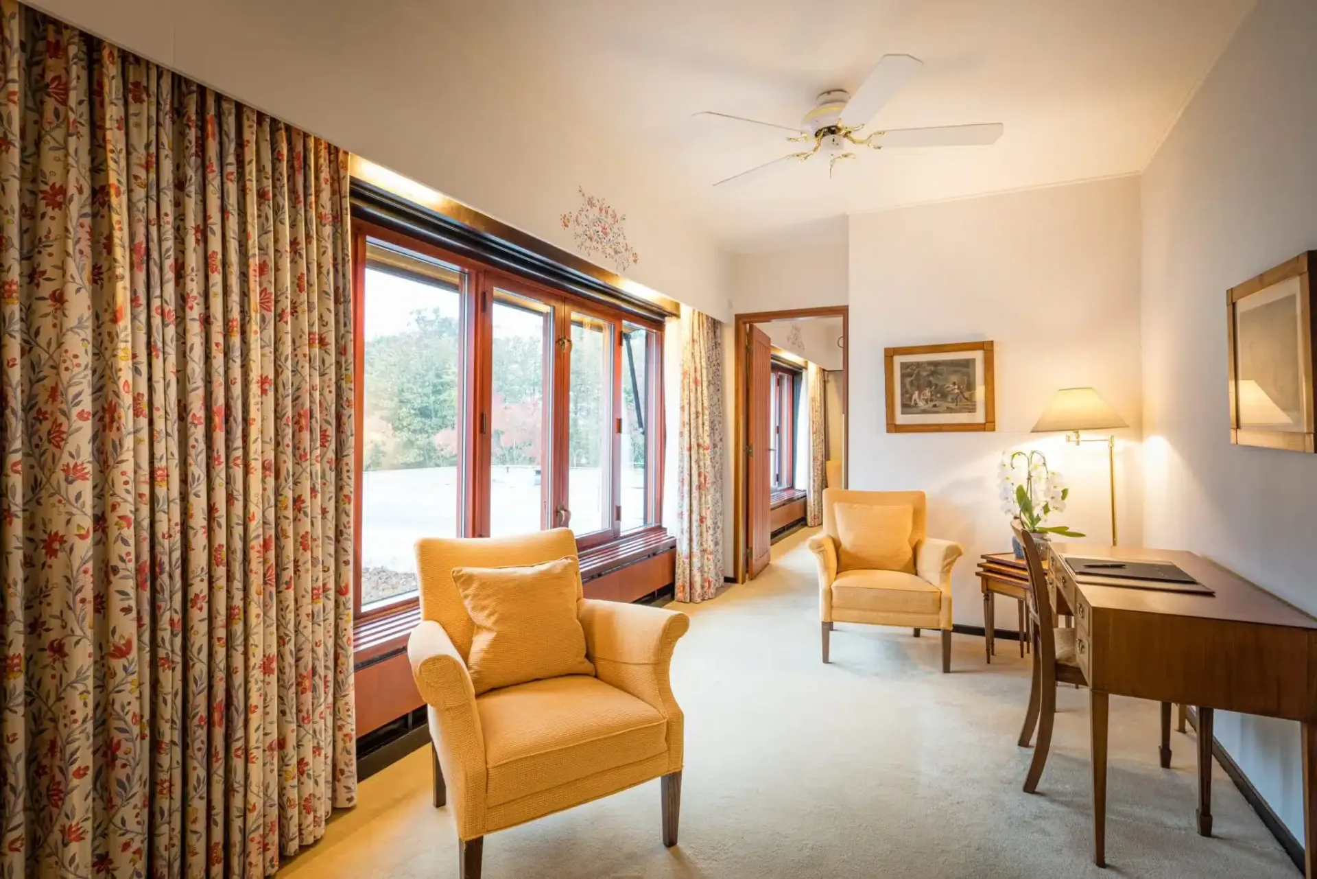 En stue med to stole, et skrivebord og en loftsventilator