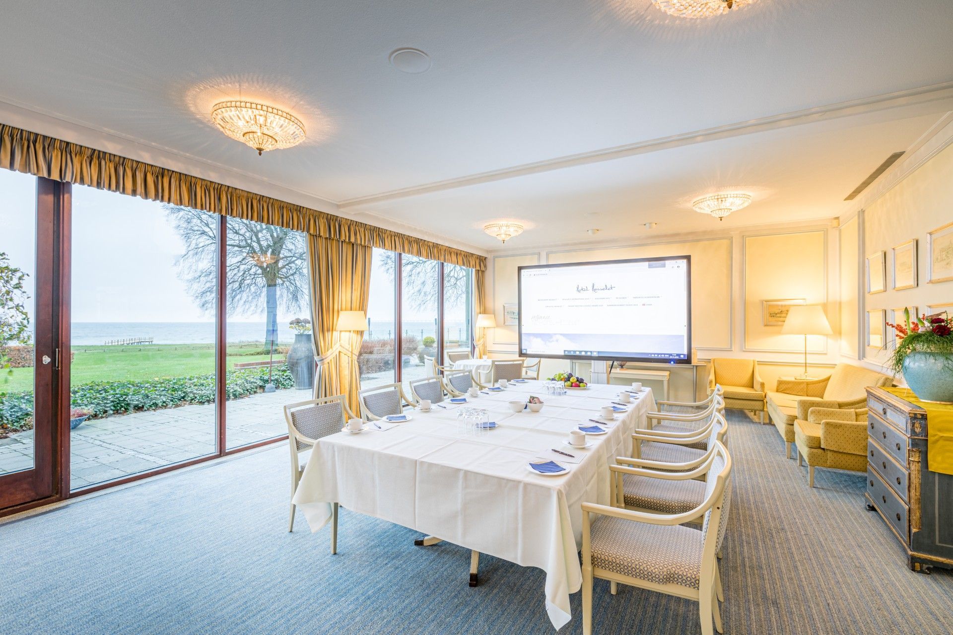 Et stort rum med et langt bord og stole i.