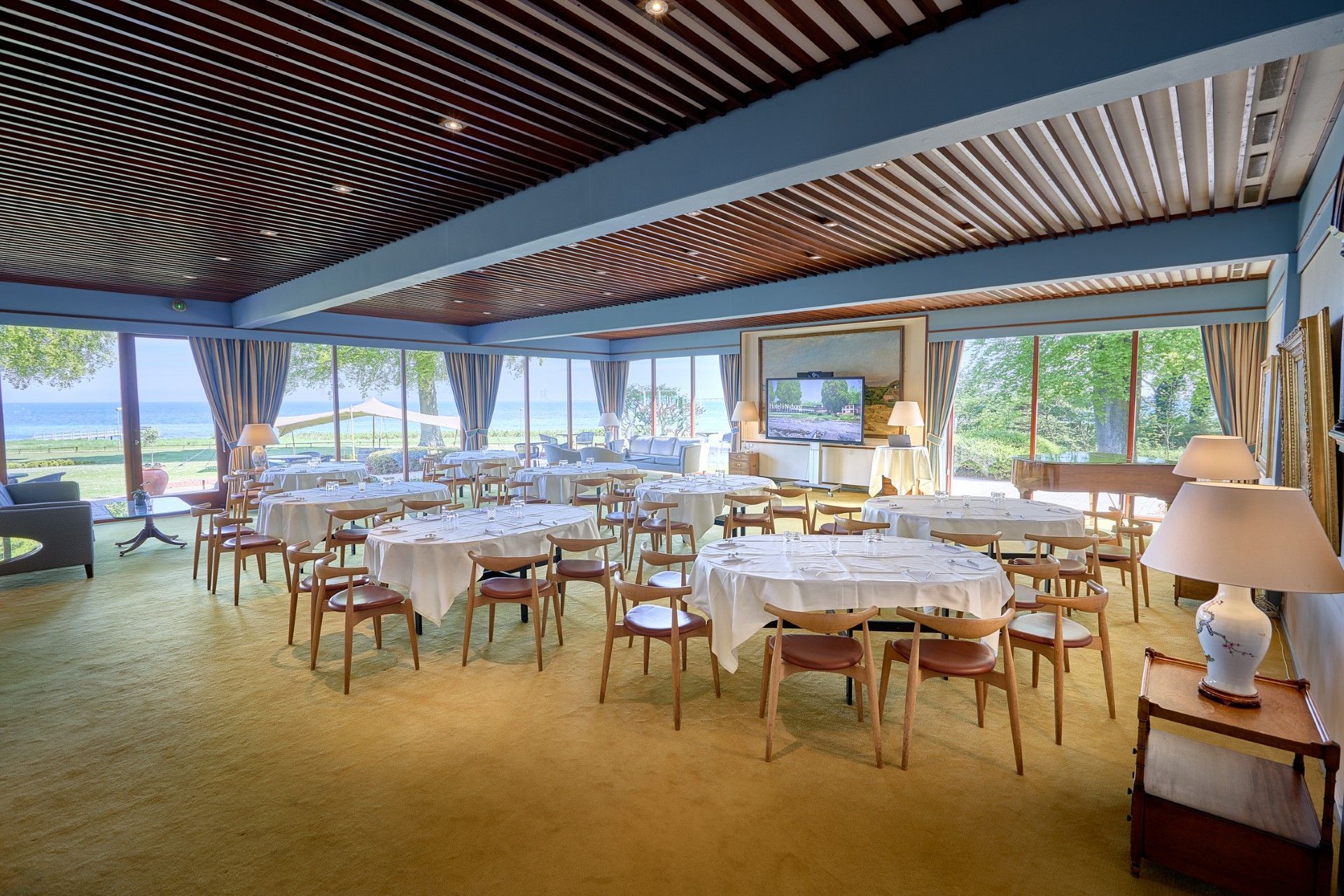 En spisestue med bord og stole og udsigt over havet