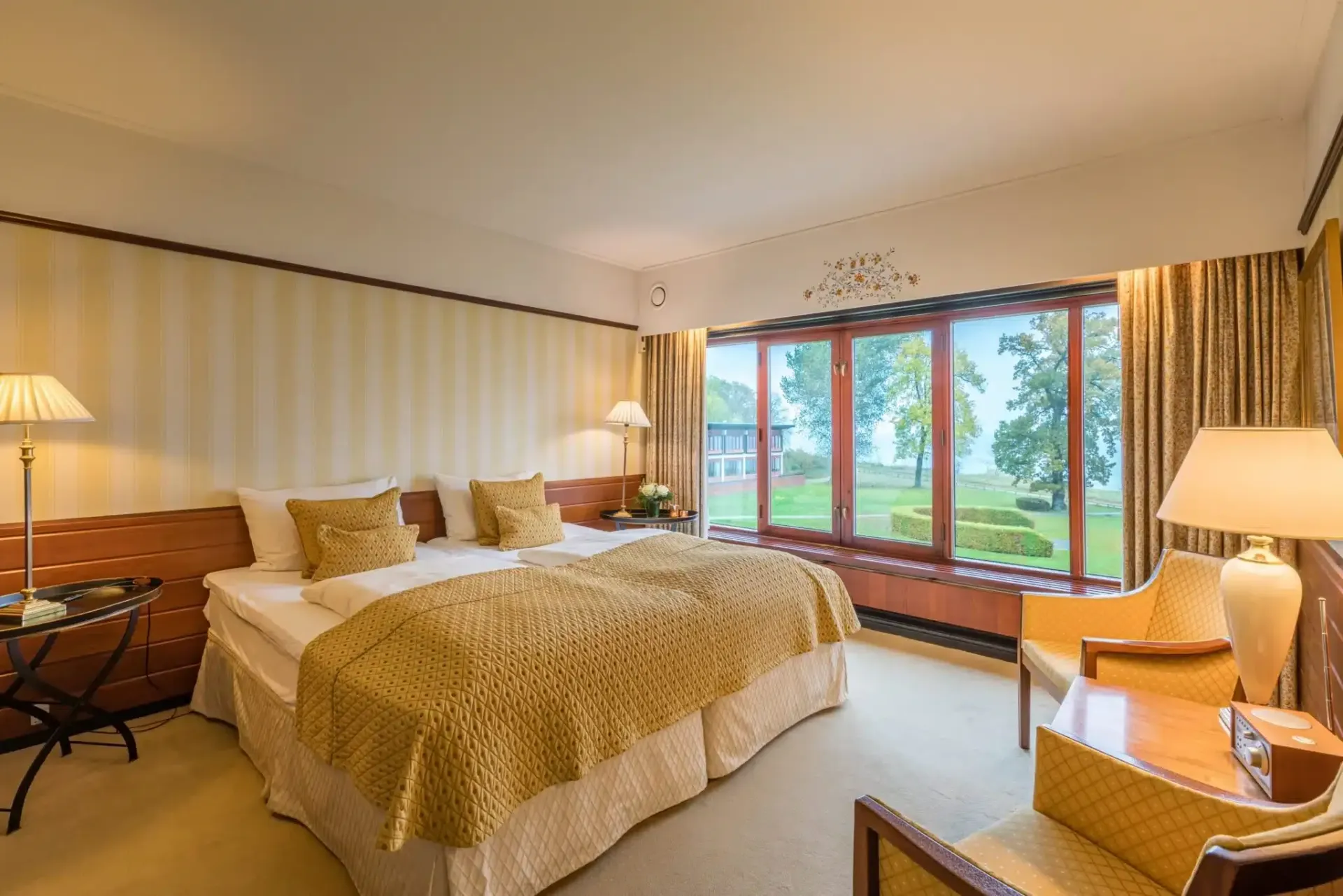 Et hotelværelse med to senge, en stol og et bord.