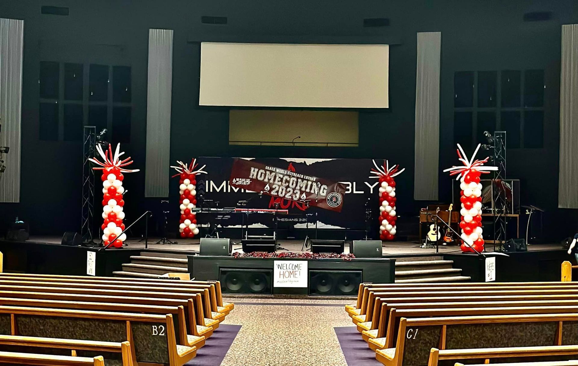 A church is decorated with balloons and a large screen