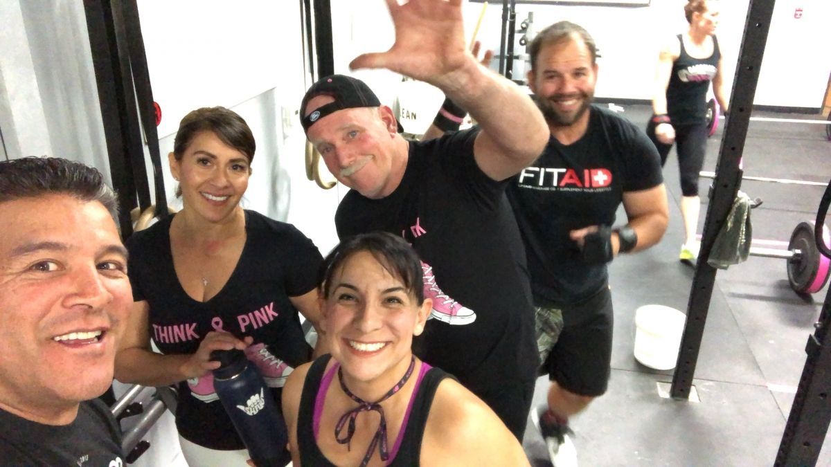 A group of people are posing for a picture in a gym.