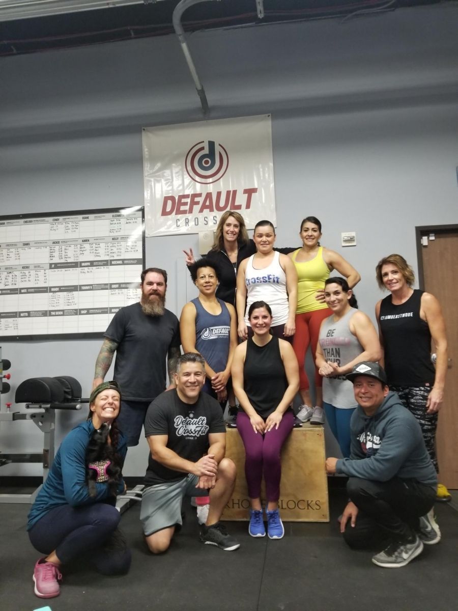 A group of people posing for a picture in front of a sign that says default