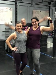 Two women are posing for a picture in a gym.