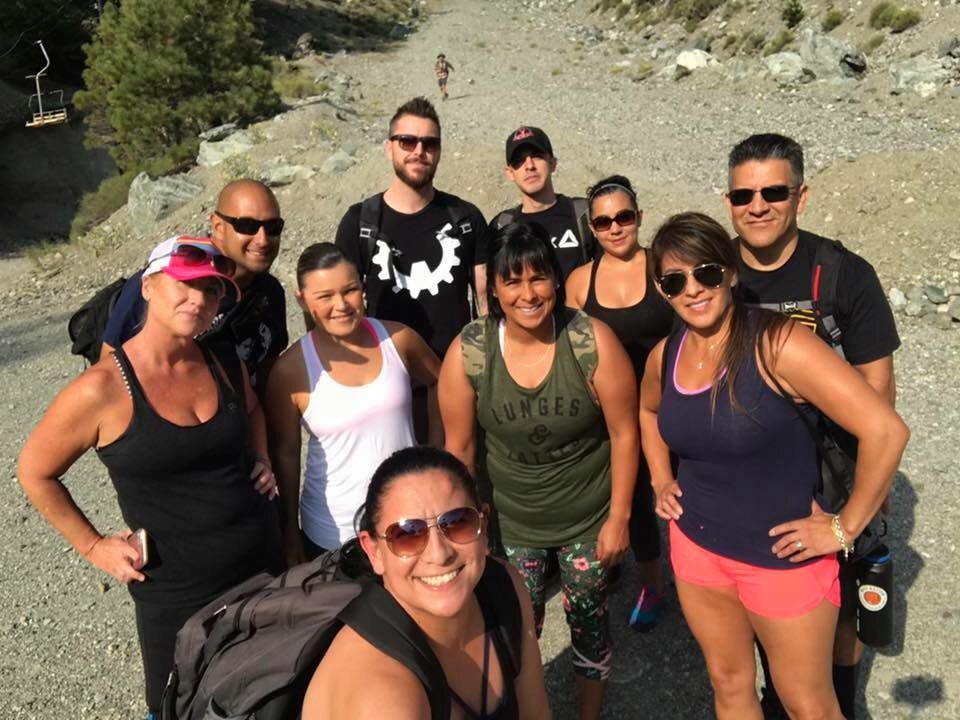 A group of people are posing for a picture on a dirt road.