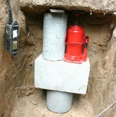 A red bottle is sitting on top of a concrete block