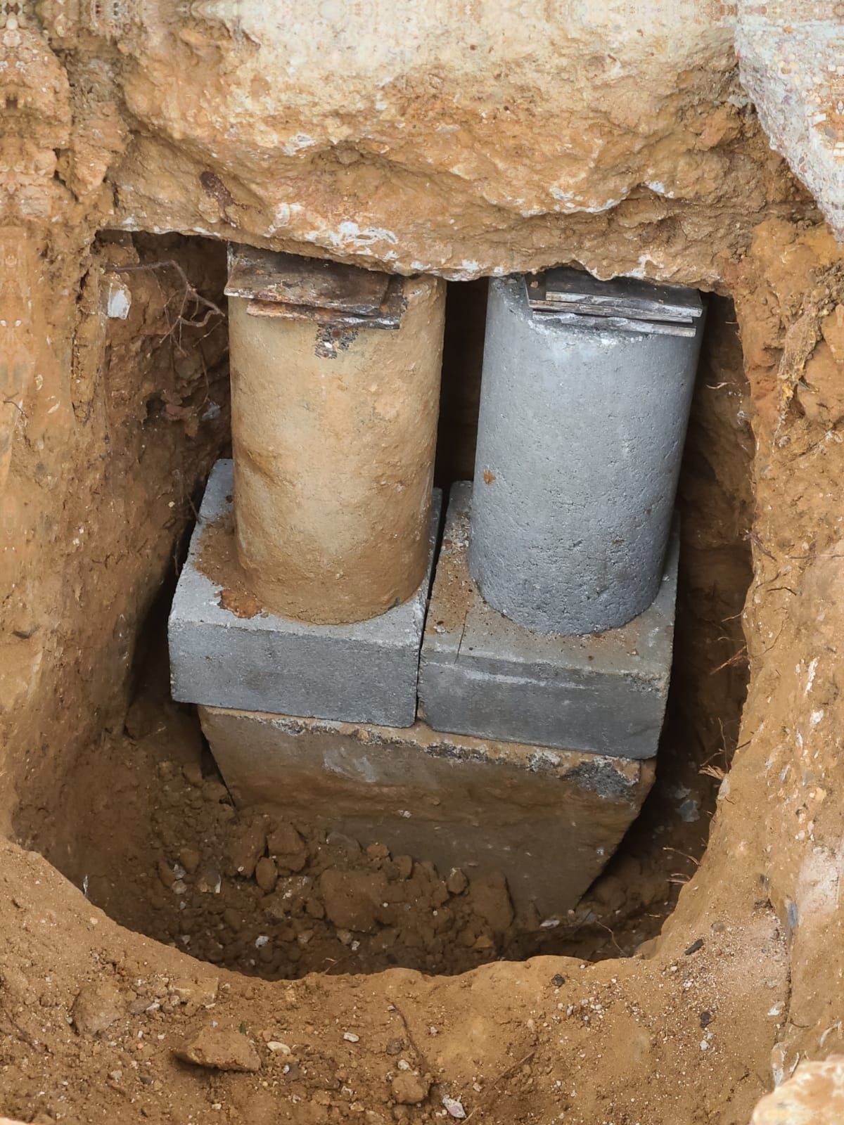 Two concrete pipes are sitting in a hole in the ground