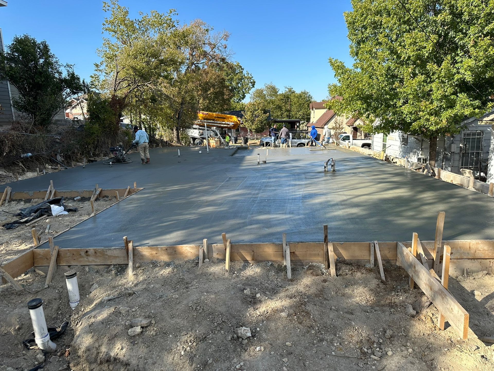 A concrete driveway is being built in front of a house.