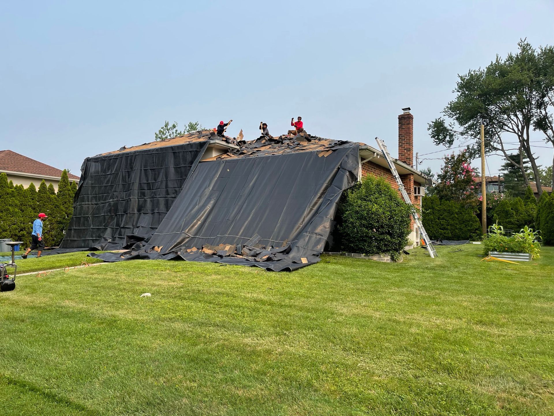 A group of people are working on the roof of a house.