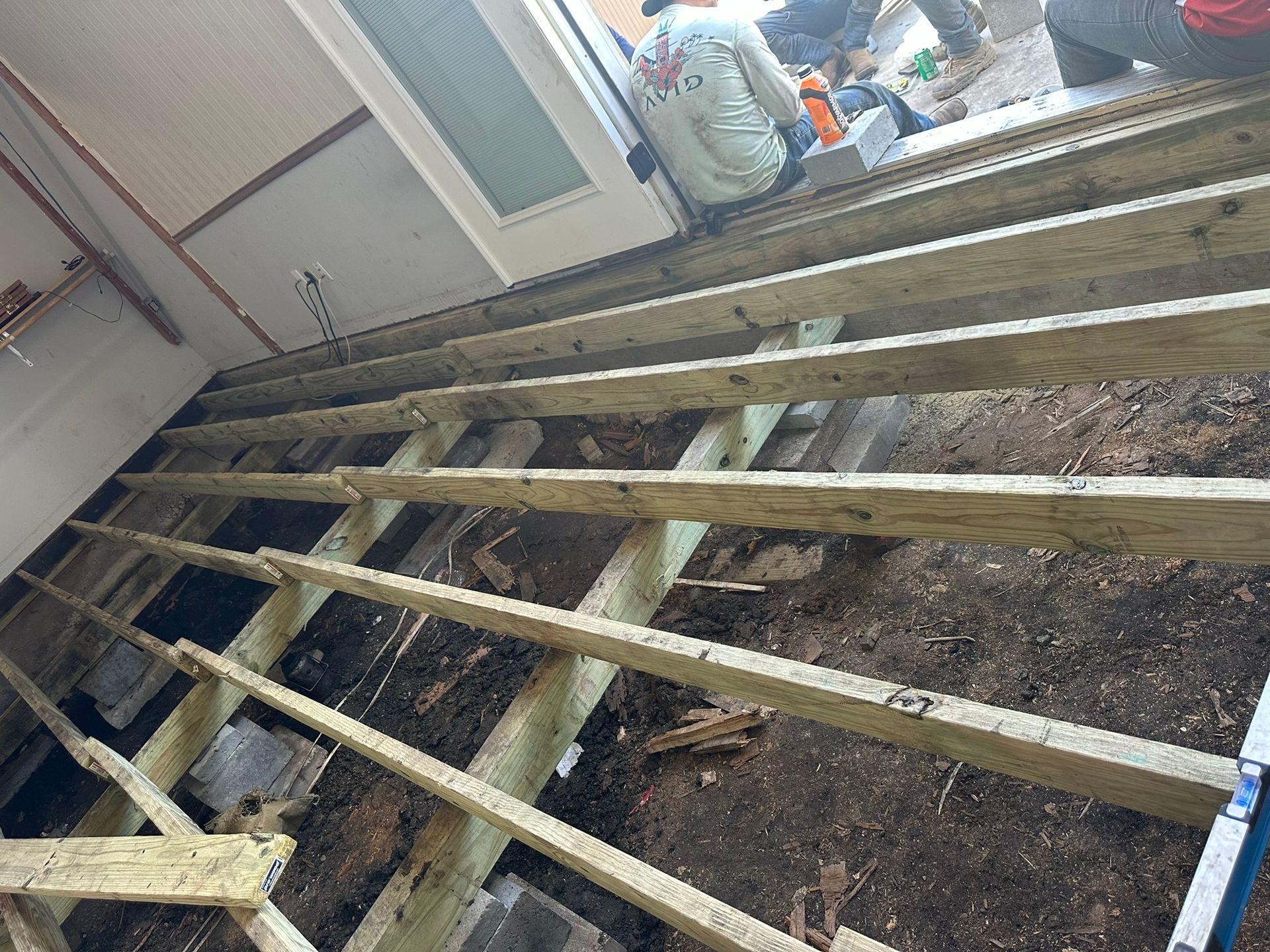 A group of people are working on a wooden floor.