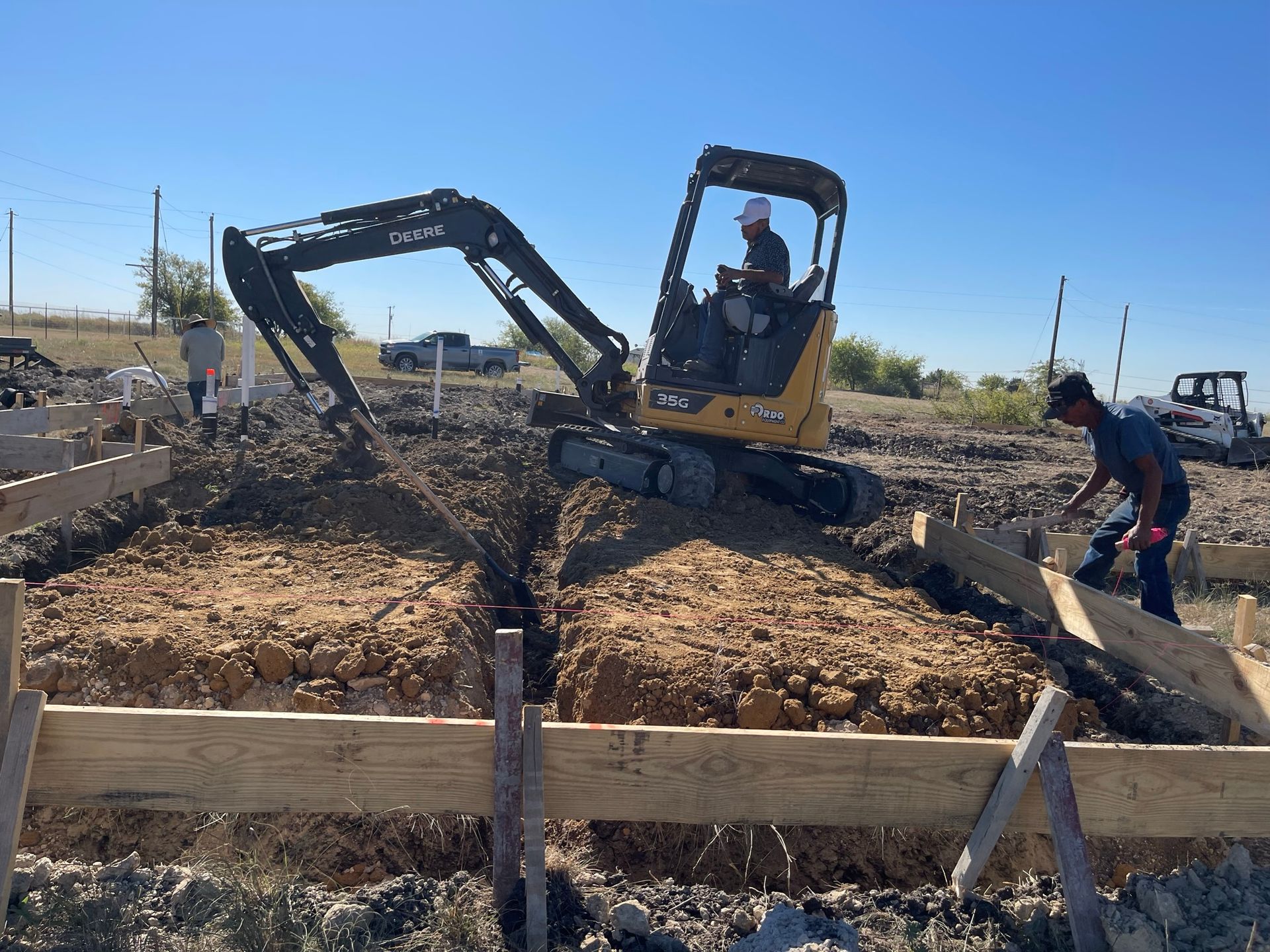 A Man is Driving a Small Excavator on a Construction Site