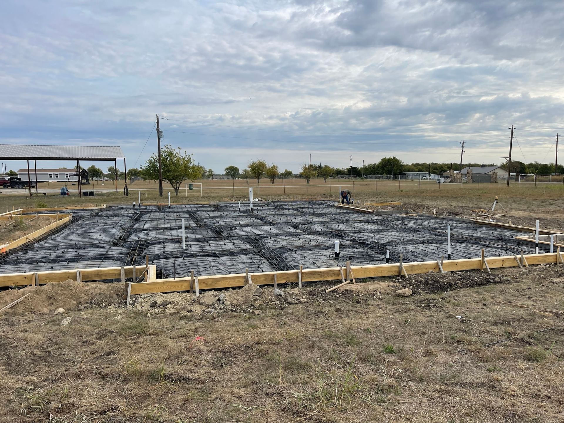 A concrete foundation is being built in a field.