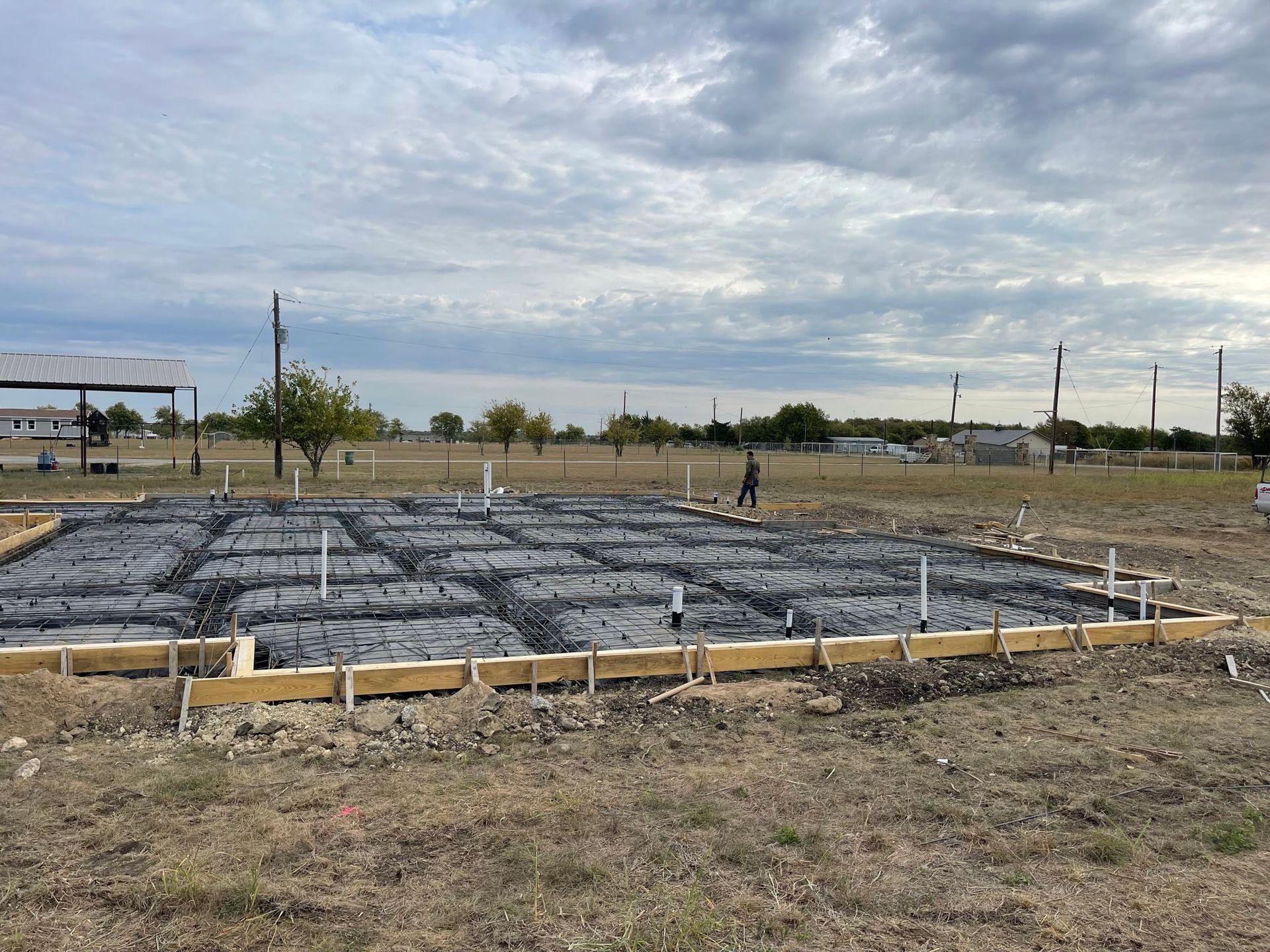 A concrete foundation is being built in a field.