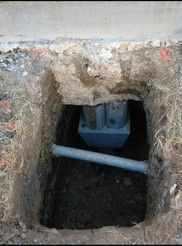 A hole in the ground with a pipe in it.