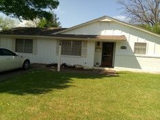 A white house with a car parked in front of it.