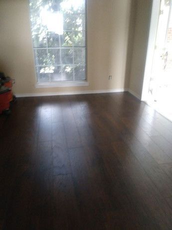 A living room with hardwood floors and a window.