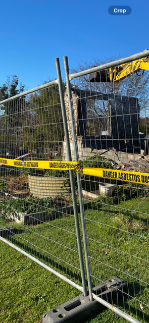 A fence is surrounding a building that is being demolished.