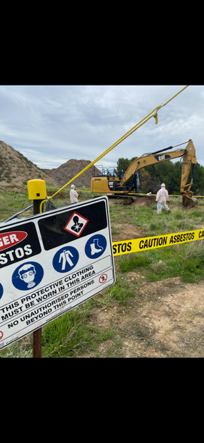 A construction site with a danger sign and caution tape.