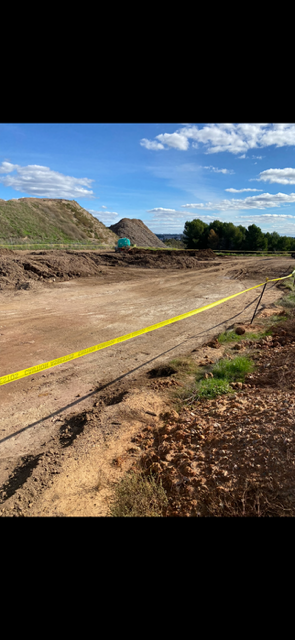 A dirt road with a yellow line on the side of it.