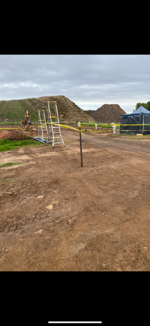 A dirt road with a scaffolding in the middle of it.