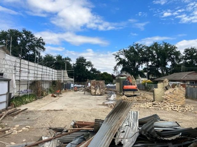 A construction site with a lot of rubble and trees in the background
