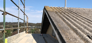 A roof with scaffolding on it and a blue sky in the background.